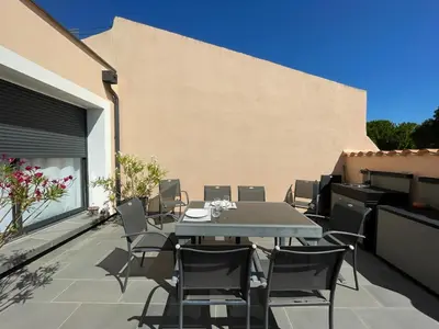 a patio with a table and chairs on a balcony at La Villa des Cistes au calme vue Étangs in Narbonne