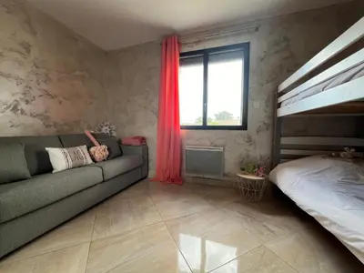 a living room with a couch and a bed at La Villa des Cistes au calme vue Étangs in Narbonne