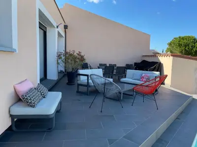 a patio with chairs and tables on a building at La Villa des Cistes au calme vue Étangs in Narbonne