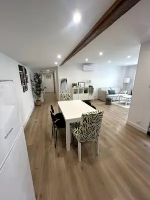 a kitchen and living room with a table and chairs at Cocon chaleureux au coeur de Mirepoix in Mirepoix