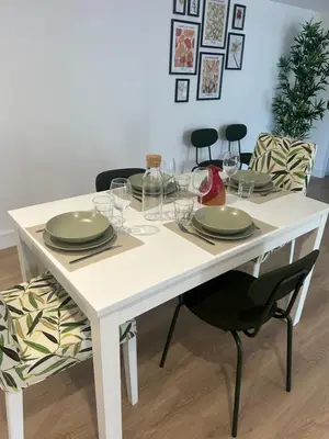 a white table with plates and wine glasses on it at Cocon chaleureux au coeur de Mirepoix in Mirepoix
