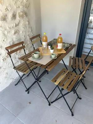 a wooden table with two chairs and two bottles of orange juice at Cocon chaleureux au coeur de Mirepoix in Mirepoix