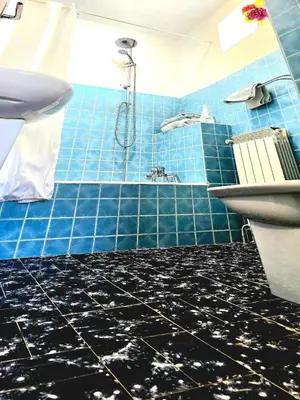 a blue tiled bathroom with a shower and a sink at Le Sanglier Noir 14 in Villeneuve-les-Corbières
