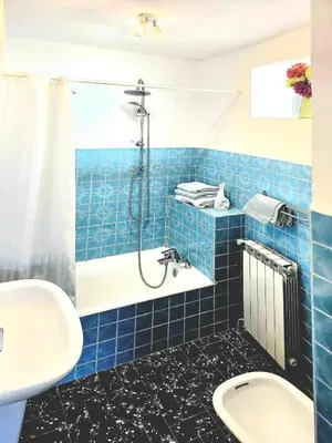 a blue tiled bathroom with a shower and a sink at Le Sanglier Noir 14 in Villeneuve-les-Corbières