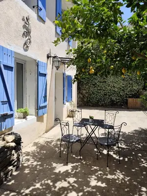 a table and chairs sitting under an orange tree at franck in Marcorignan