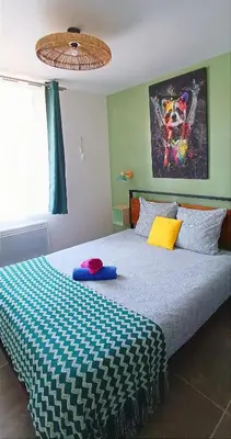 a bedroom with a bed with a blue and white checkered blanket at Perrutel - entre Bastide et cité in Carcassonne