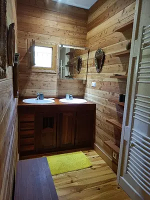 a wooden bathroom with two sinks and a mirror at Maison chaleureuse en Ariège in Roquefort-les-Cascades