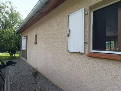 a window with a shutter on the side of a house at Maison chaleureuse en Ariège in Roquefort-les-Cascades