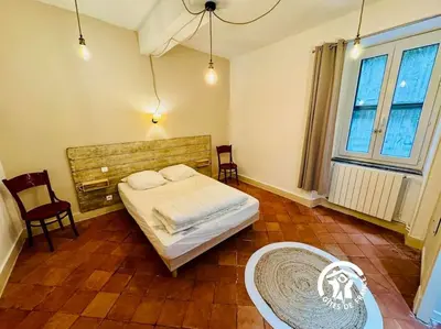 a bedroom with a bed and a table and a window at Domaine 15 pers, Piscine, Pétanque, Canal du midi in Carcassonne