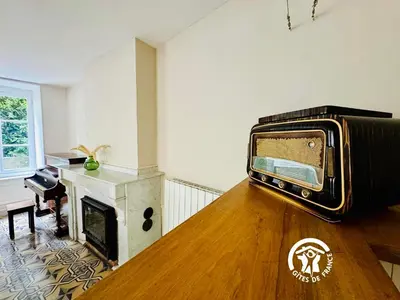 a living room with a tv sitting on the wall at Domaine 15 pers, Piscine, Pétanque, Canal du midi in Carcassonne