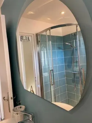 a mirror over a bathroom sink with a shower at Charmante maison de ville in Mirepoix