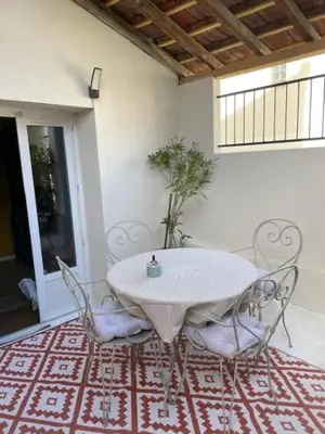 a white table and chairs on a red and white rug at Charmante maison de ville in Mirepoix
