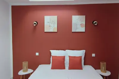 a bedroom with a bed with three pictures on the wall at Charmante maison in Carcassonne
