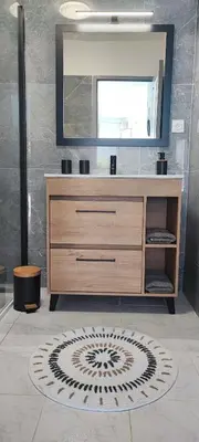a bathroom with a wooden dresser and a mirror at Charmante maison in Carcassonne