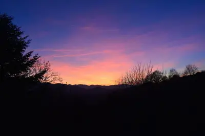 a sunset in the sky with trees and mountains at Cozy Tiny House plus SPA - à Pereille d'en Haut in Péreille