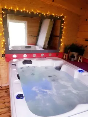 a tub in a room with a mirror and lights at Cozy Tiny House plus SPA - à Pereille d'en Haut in Péreille