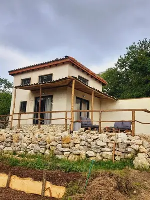 a house with a stone wall in front of it at Cozy Tiny House plus SPA - à Pereille d'en Haut in Péreille