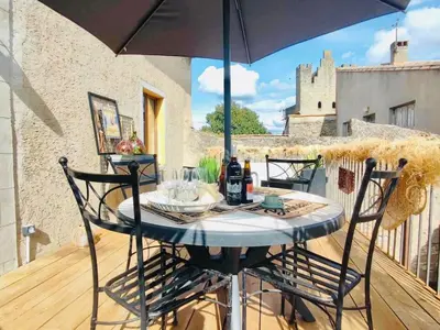 a table and chairs on a balcony with an umbrella at Le Rendez Vous - 4 étoiles - parking gratuit in Carcassonne