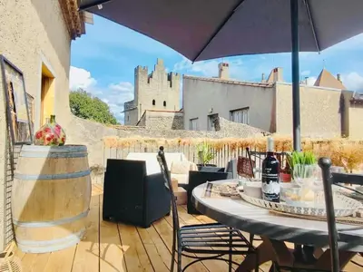 a patio with a table and chairs and an umbrella at Le Rendez Vous - 4 étoiles - parking gratuit in Carcassonne