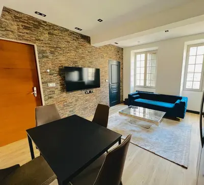 a living room with a black table and a brick wall at Good vibes in Limoux