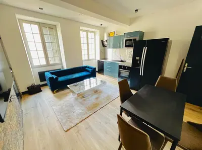 a living room with a blue couch and a kitchen at Good vibes in Limoux