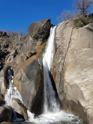 a waterfall on the side of a rocky mountain at Chambre d'hote la passerelle in Mazamet