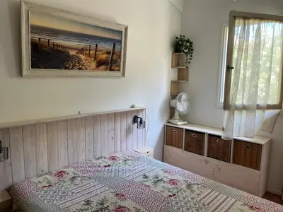 a bedroom with a bed and a picture on the wall at Charmant T3 climatisé avec terrasse, proche plage & parking privé - 4/6 pers, Gruissan - FR-1-796-7 in Gruissan