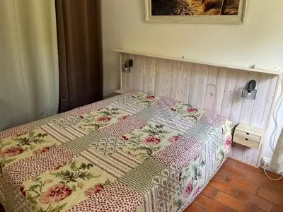 a bed with a quilt on it in a bedroom at Charmant T3 climatisé avec terrasse, proche plage & parking privé - 4/6 pers, Gruissan - FR-1-796-7 in Gruissan