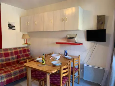 a dining room with a table and a couch at T2 cabine climatisé avec piscine, parking privé, proche port et commerces, idéal 4-5 pers. - FR-1-796-9 in Gruissan