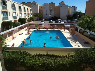 a group of people in a swimming pool at **Gruissan : T2 cosy avec piscine, parking privé, proche plage et commerces** - FR-1-796-8 in Gruissan