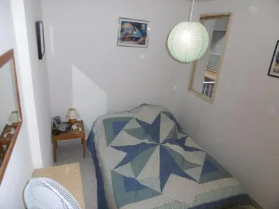a room with a bed with a quilt on it at **Gruissan : T2 cosy avec piscine, parking privé, proche plage et commerces** - FR-1-796-8 in Gruissan