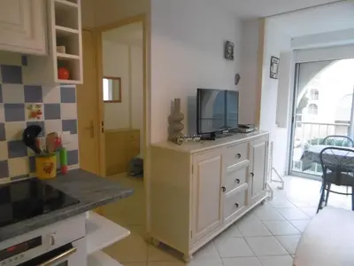 a kitchen with a tv on top of a cabinet at **Gruissan : T2 cosy avec piscine, parking privé, proche plage et commerces** - FR-1-796-8 in Gruissan