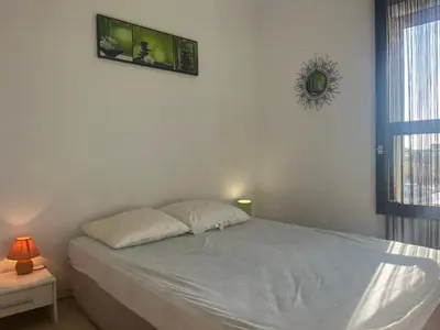 a bedroom with a white bed with a window at Gruissan: T2 Cabine, Piscine, Parking, Centre, 4/5 pers, Petit Budget - FR-1-796-3 in Gruissan