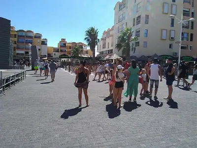 a group of people walking down a street at Gruissan: T2 Cabine, Piscine, Parking, Centre, 4/5 pers, Petit Budget - FR-1-796-3 in Gruissan