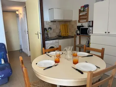 a table with plates and glasses on it in a kitchen at Gruissan: T2 Cabine, Piscine, Parking, Centre, 4/5 pers, Petit Budget - FR-1-796-3 in Gruissan