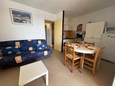 a room with a bed and a table and a kitchen at Gruissan: T2 Cabine, Piscine, Parking, Centre, 4/5 pers, Petit Budget - FR-1-796-3 in Gruissan