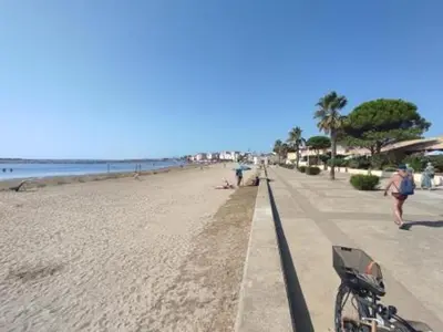 a bike parked on a beach next to the ocean at Gruissan - Studio rénové climatisé 2/3 pers, parking sécurisé, à 50m de la plage du Grazel - FR-1-796-16 in Gruissan