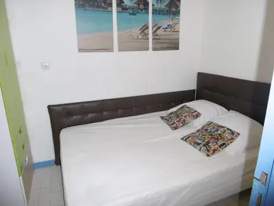 a bed with two pillows on it in a bedroom at Gruissan: T3, 4 Pers, Piscine, Parking, Proche Commerce, Environnement Calme, Accès Plage - FR-1-796-14 in Gruissan