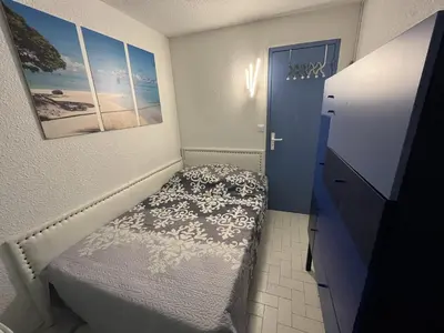 a small bedroom with a bed and a cabinet at Gruissan: T3, 4 Pers, Piscine, Parking, Proche Commerce, Environnement Calme, Accès Plage - FR-1-796-14 in Gruissan