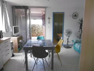 a kitchen with a table and chairs in a room at Gruissan: T3, 4 Pers, Piscine, Parking, Proche Commerce, Environnement Calme, Accès Plage - FR-1-796-14 in Gruissan