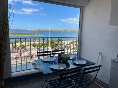 a table with a view of the beach from a balcony at Gruissan - À 2 Pas de la Plage - Studio Cabine pour 4 - Parking Sécurisé - FR-1-796-15 in Gruissan
