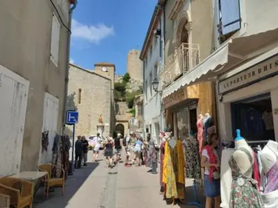 a group of people walking down a city street with shops at Gruissan - À 2 Pas de la Plage - Studio Cabine pour 4 - Parking Sécurisé - FR-1-796-15 in Gruissan
