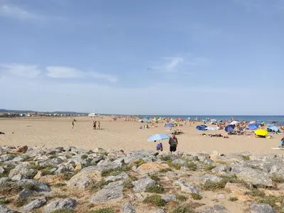 a group of people on a beach with umbrellas at Gruissan - À 2 Pas de la Plage - Studio Cabine pour 4 - Parking Sécurisé - FR-1-796-15 in Gruissan