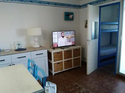 a living room with a television and a bed at Gruissan - À 2 Pas de la Plage - Studio Cabine pour 4 - Parking Sécurisé - FR-1-796-15 in Gruissan
