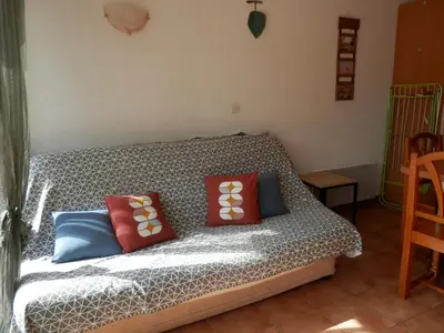 a couch with pillows on it in a room at T2 RDC avec Terrasse, Piscine & Parking - Proche Vieux Village de Gruissan - FR-1-796-20 in Gruissan