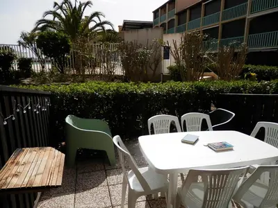 a table and chairs and a white table and chairs at T2 RDC avec Terrasse, Piscine & Parking - Proche Vieux Village de Gruissan - FR-1-796-20 in Gruissan