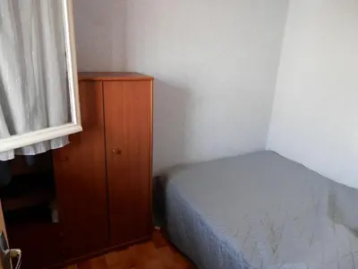 a small bedroom with a bed and a wooden cabinet at T2 RDC avec Terrasse, Piscine & Parking - Proche Vieux Village de Gruissan - FR-1-796-20 in Gruissan