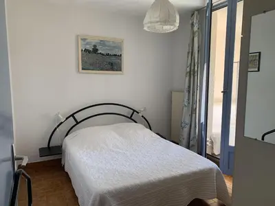 a bedroom with a bed and a picture on the wall at T2 Confort Centre Port 4 Pers - Clim - Parking - Ascenseur - FR-1-796-25 in Gruissan