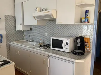 a kitchen counter with a microwave and a sink at T2 Confort Centre Port 4 Pers - Clim - Parking - Ascenseur - FR-1-796-25 in Gruissan