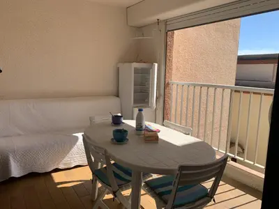 a small table and chairs in a room with a balcony at T2 Confort Centre Port 4 Pers - Clim - Parking - Ascenseur - FR-1-796-25 in Gruissan